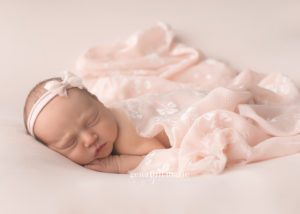 newborn girl with pink wrap