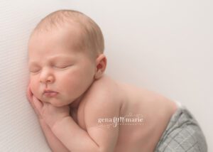 newborn hands folded beneath head